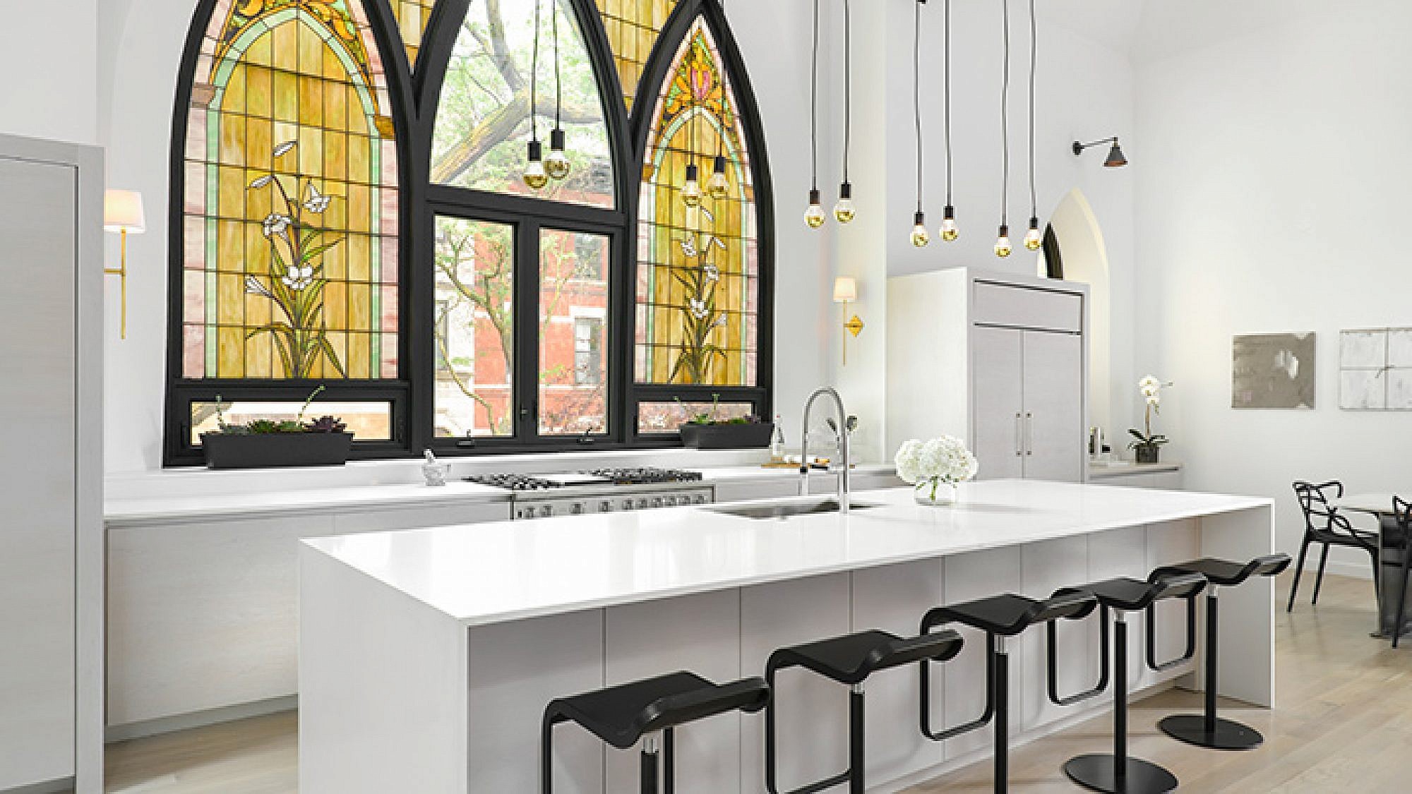 המטבח ניחן בעיצוב לבן ומינימליסטי המפנה את במה לחלון הוויטראז' המקורי, הגדול והמרשים | צילום: Jim Tschetter