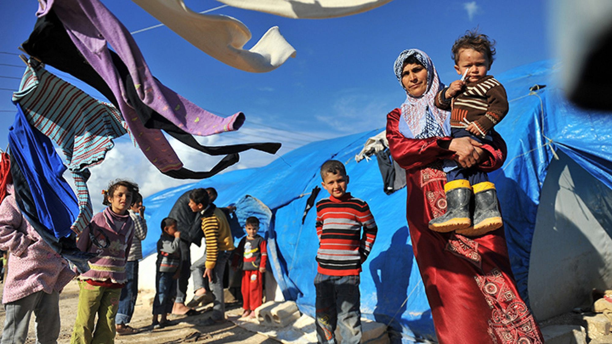 אם אוחזת בבנה במחנה הפליטים הסורי (למצולמים אין קשר לכתבה) | צילום: AFP