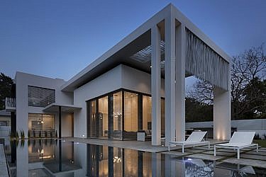 בית גדול בעיצוב נקי: חזיתות לבנות ועמודים ישרים עם מסך הצללה פיסולי ממוטות פלדה שמוסיף עניין | צילום: אסף פינצ'וק