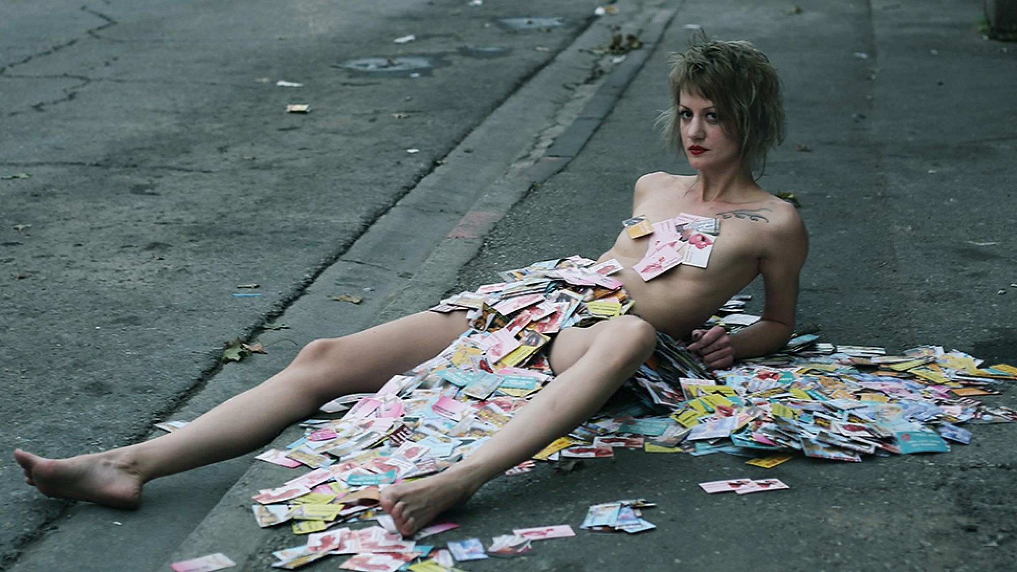 האמנית סשה קורבטוב מכוסה בכרטיסי ביקור של זנות | צילום: וננה בוריאן