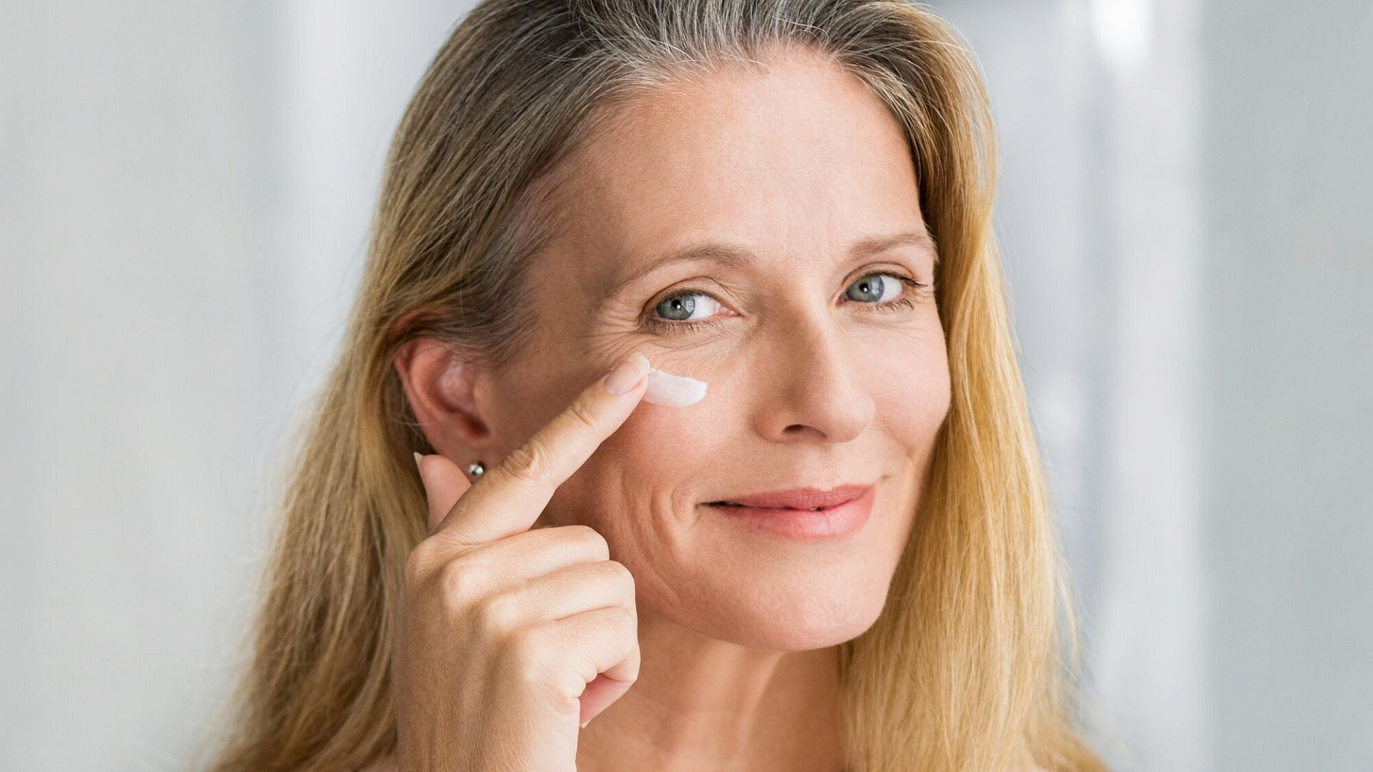 אשה מורחת קרם פנים | צילום: shutterstock