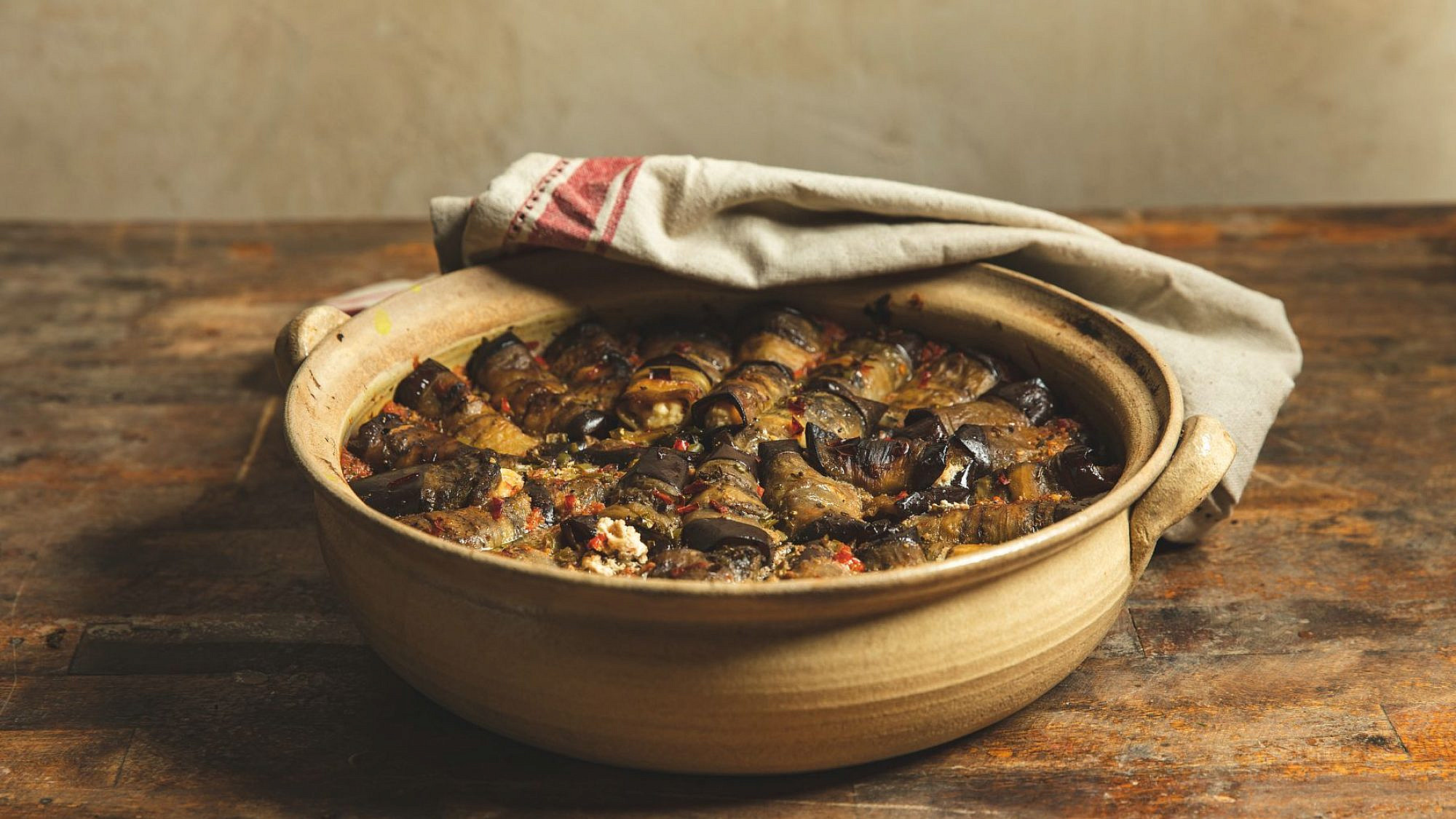 גלילי חצילים עם גבינות ברוטב עגבניות של מיכל חביביאן | צילום: שני בריל; כלים: הגר הירש, קדרית