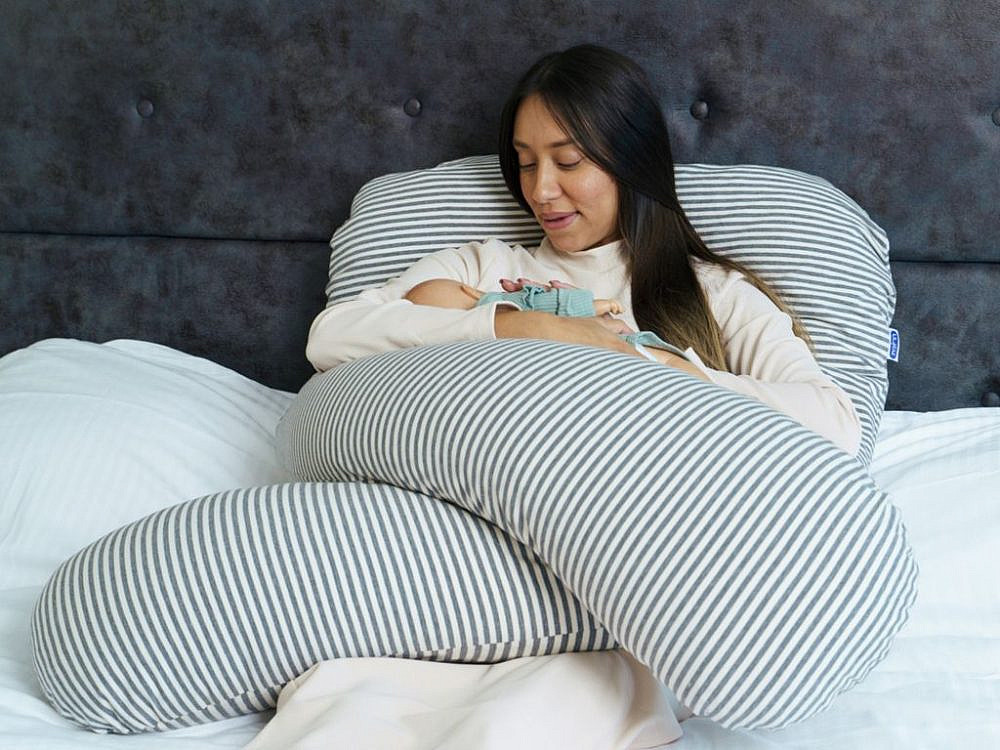 תמונה של אישה משתמשת בכרית הנקה על המיטה. צילום: מיכאל קמינסקי