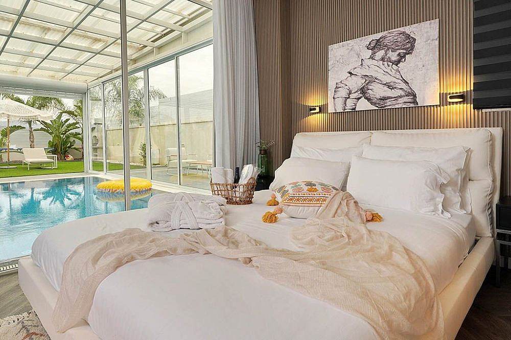 המיטה המפנקת בסוויטה, הצופה לבריכה הפרטית. אלומות יוסף. צילום: תומר