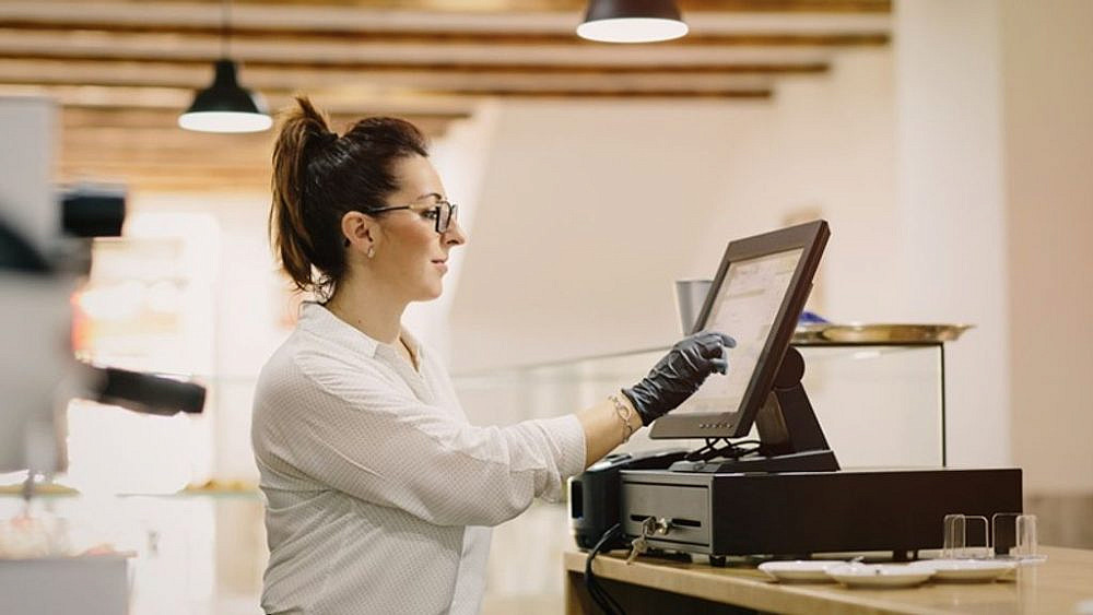 אישה מתפעלת את מערכת ההזמנות בבית קפה. צילום: Shutterstock